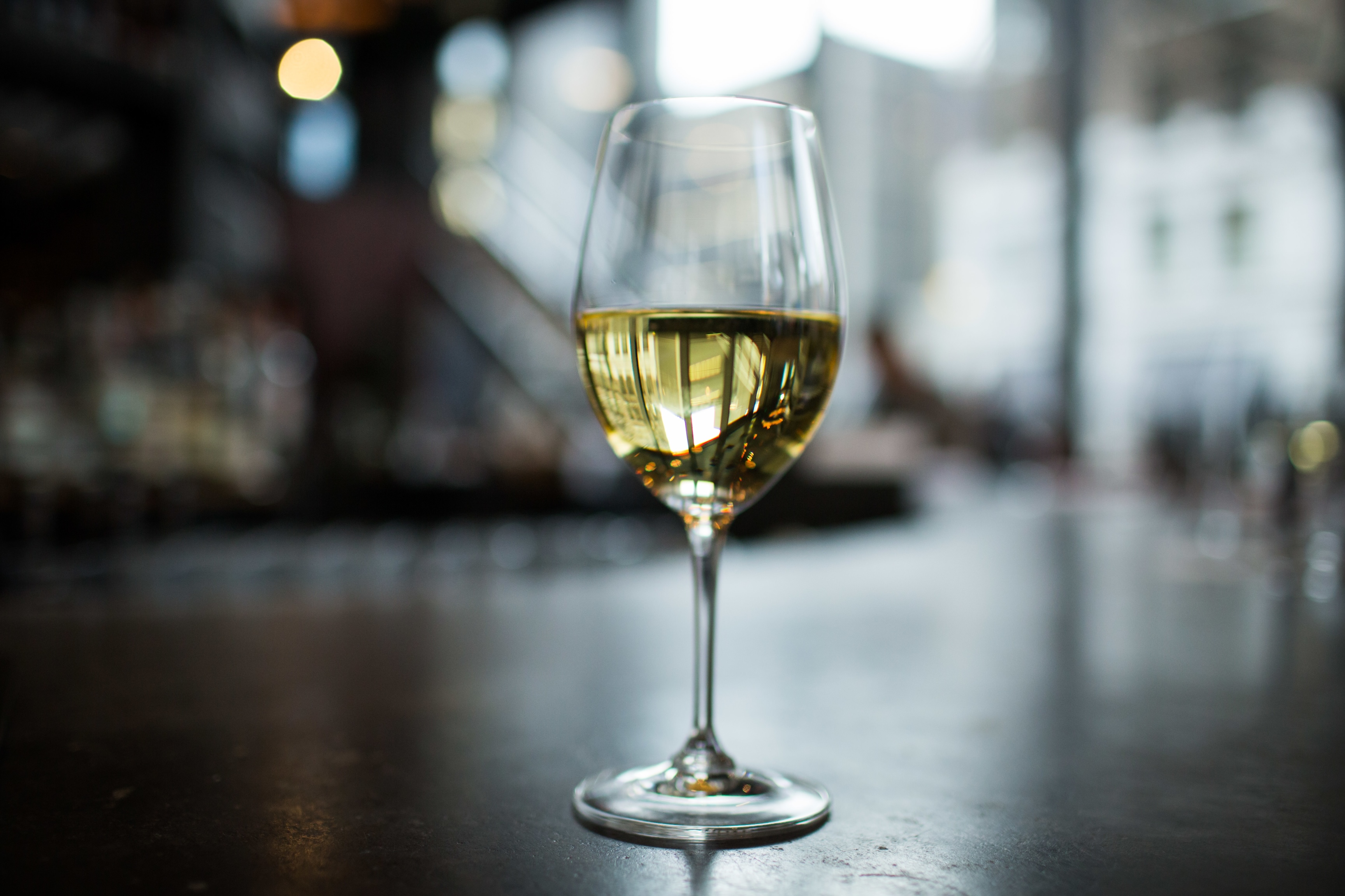 Glass of champagne on a black surface with the building columns reflecting in it Glass of champagne on a black surface with the building columns reflecting in it